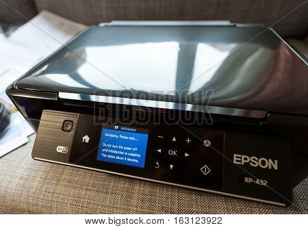 PARIS FRANCE - NOV 12 2016: Side view of the initializing process of a new Epson XP-432 home printer after un packing