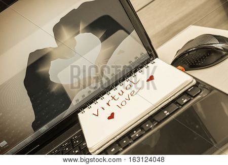 notebook for notes lying on the office desk with the inscription virtual love