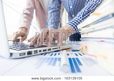 Team work process. young business managers crew working with new startup project. labtop on wood table typing keyboard texting message analyze graph plans