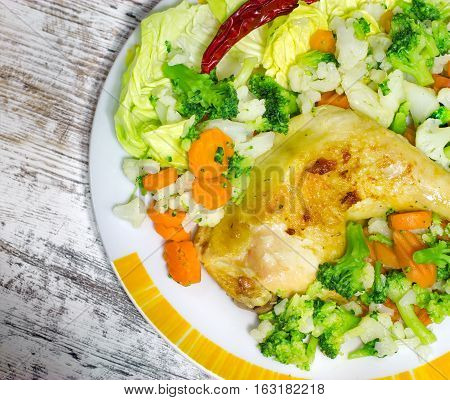 Freshly prepared tasty (delicious) meal - chicken drumstick and boiled vegetables
