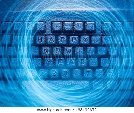 keyboard covered with snow with words Happy New Year and 2017 illuminated with blue light