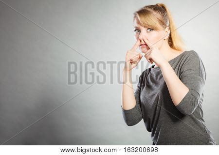Blonde Girl Holding Nose.