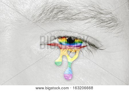 Crying rainbow eye with rainbow flag iris on black and white face. Concept of sadness and pain for the homosexual discrimination. Flag symbol of pride and freedom LGBT.