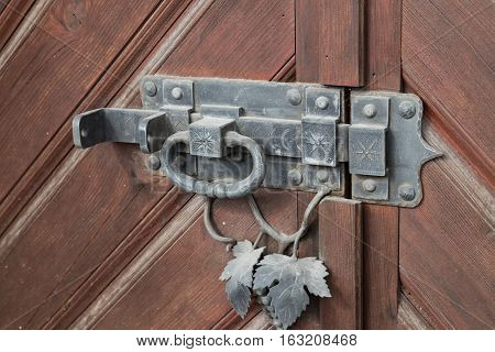 Vintage iron door lock - heck with knocker on the wooden brown door