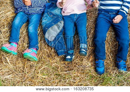 Children in jeans posing in the hayloft