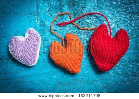 Valentine's Day. Colorful knitted hearts. Red heart on the blue boards. Valentines day. Heart pendant. Red heart. Valentine cards. Space for text. Eighth of March. International Women's Day.