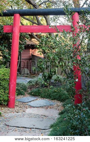 Sydney, Australia - May 22, 2016: At the popular Auburn Botanic Gardens, Japanese Zen Gardens section featuring the Ryoan-ji style designs. A red torii gate and pathway leading to the rest house.