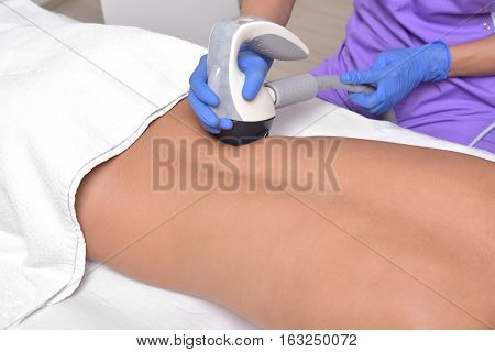 Young beautiful woman gets professional skin treatment in a beauty clinic. Body shaper