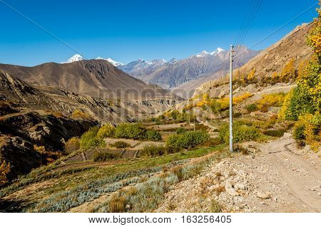 Mountain valley with terraced fields near town of Jhong. Annapurna circuit trek in Nepal.