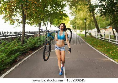 woman carrying your bike on the road in the Park