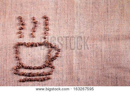 Cup With Roasted Coffee Beans On The Burlap Background