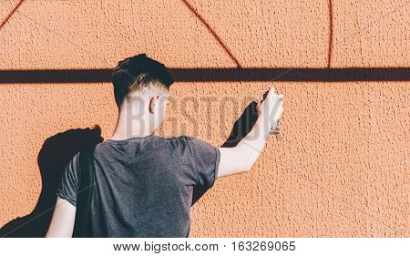 Man writing graffiti on the urban walls