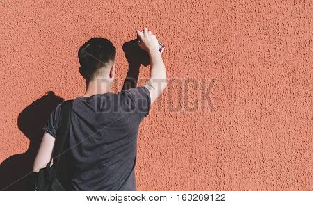 Man writing graffiti on the urban walls