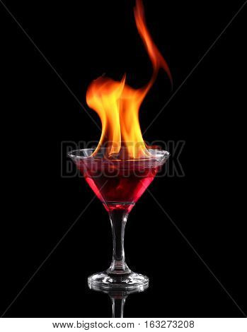 the Flaming cocktail in glass over black background