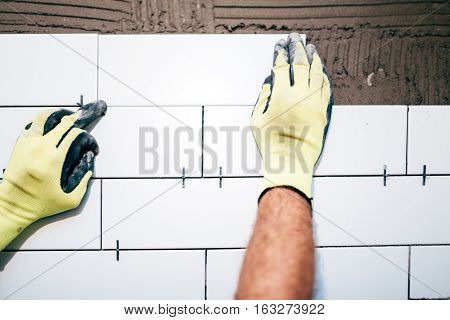 Industrial Worker Hands Installing Ceramic Tiles On Interior Walls, Handyman Using Plastic Distancer