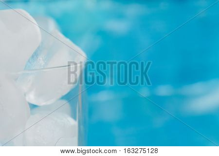 Ice cubes in a glass on blue background