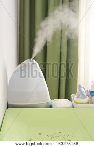 Baby room air humidifier puffing steam indoors
