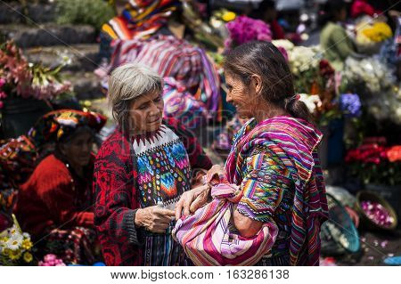 Chichicastenango Guatemala - April 27 2014: Two local women wearing traditional clothing in a street market in the town of Chichicastenango in Guatemala