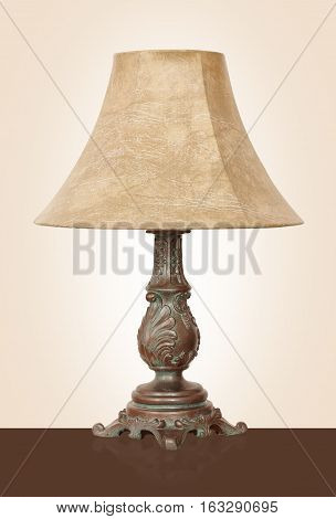Light fixture - Vintage Desk lamp with the powerful brass basis on a beige background