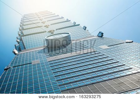 Business concept for real estate and corporate construction:Looking up view of Taipei 101 the landmark of Taiwan reflect blue sky and sun lights
