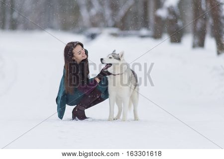 Human and Pet Relationships. Caucasian Brunette Woman Playing with Husky Dog Outdoors in Park. Horizontal Shot
