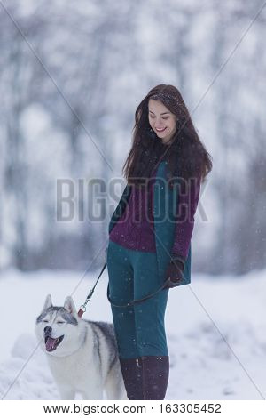 Lovely Couple. Portrait of Smiling and Happy Caucasian Woman Airing Her Husky Dog Outdoors in Forest.Vertical Image