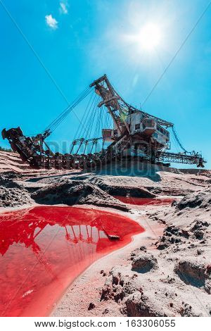 multi bucket excavator, giant stacker, absetzer in career. red water rich in minerals