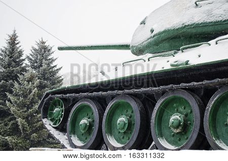 T34 tank covered with snow standing on the forest background
