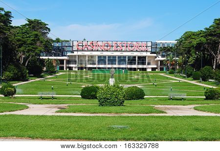 Estoril, Portugal - October 23, 2014. View of Casino Estoril with grass lawns in front of casino, vegetation, benches and statue.