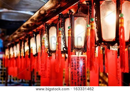 Red lantern people pray to god for blessing in traditional old oriental chinese temple in Hong Kong(HK) (Chinese Translation on paper : wish all the best for life)
