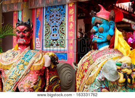 Taiwan - April 30 2016 : God statue in traditional old oriental chinese temple in Taiwan (Chinese Translation on god's strap : mazu temple on couplet : god bless people)