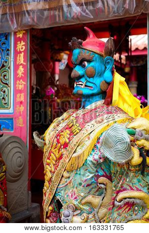 Taiwan - April 30 2016 : God statue in traditional old oriental chinese temple in Taiwan (Chinese Translation on god's strap : mazu temple on couplet : god bless people)