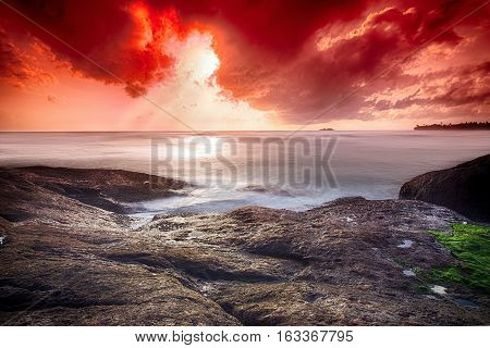 Infernal sunset in the ocean - wide angle landscape photo of ocean waves with long exposure.