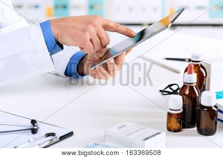 Doctor's Hands Working On A Digital Tablet At His Office