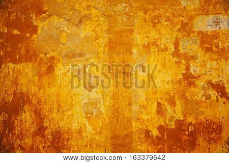 Empty space for text or image. The texture of the concrete walls are painted in orange-yellow