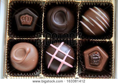 Box of six chocolates, each tempting in dark,white or milk chocolate
with designs on top.
