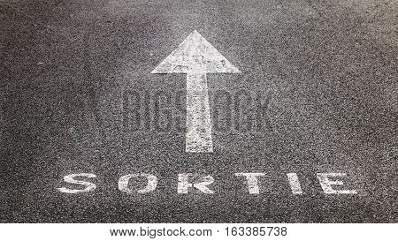 old white arrow on the road indicating the exit in French