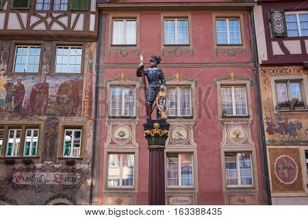 Statue of a warrior on a background of houses decorated with frescoes in Stein am Rhein, Switzerland