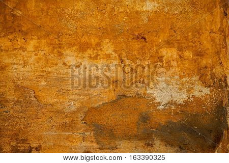 The rough surface of the rough stone yellow. Background in grunge style. texture of old wall with peeling paint. Abstract background yellow