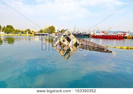 sunken boat reflected on water at Eleusis Greece
