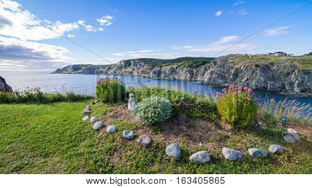 Garden by the sea in Twillingate, Newfoundland.   

Simple flower and shrub garden in summer at the top of a cliff near the ocean's edge in a Newfoundland village.