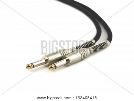 Black audio instrumental cable with two silver mono plugs isolated on white close up