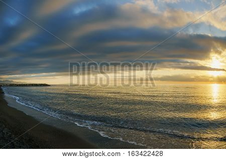 Maremma beach coast and Elba island on horizon. Sunset time. Mediterranean sea Cecina Tuscany Italy Europe.