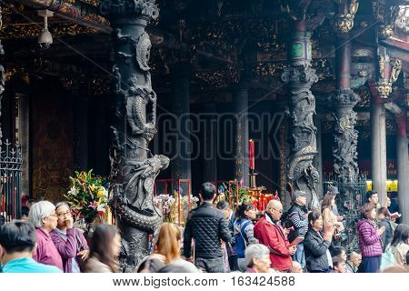 Taipei, Taiwan - Dec. 3 : Asia culture concept - people pray for god in famous heritage landmark the traditional old oriental Chinese temple lungshan with with beautiful dragon pillar decoration at Dec. 3 2016
