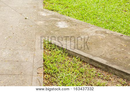 Junction of walking path or walkway or walkpath in garden with green grass.