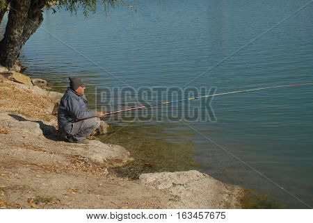 ADANA/TURKEY-DECEMBER 9, 2016:  Old fisherman at the riverside of Seyhan River of Adana. December 9, 2016-Adana/Turkey