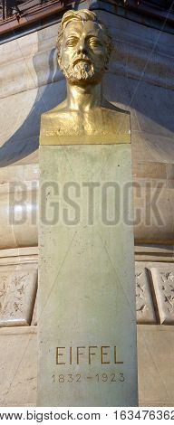 Paris, France, 10 18, 2014: The bronze gilded bust of Gustave Eiffel by Antoine Bourdelle unveiled in 1929, located at the north pier of the Eiffel Tower on the Champ-De Mars