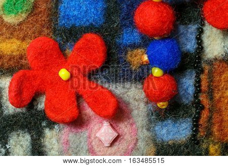 Multicolor abstract fabric texture of wool with flower and beads . Craft background
