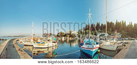 Panoramic view of colorful fishing boats docked in the harbor of Kalami, Corfu island, Greece