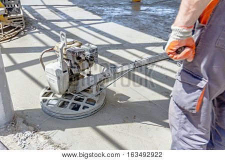 Self leveling power trowel machine sander for smoothing surface to finish concrete slab.